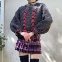 a girl wearing a plaid skirt and sweater
