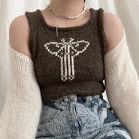a woman wearing a sweater with a bee on it