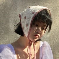 a woman in a white shirt wearing a knitted hat