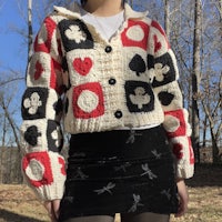 a woman wearing a cardigan with playing cards on it